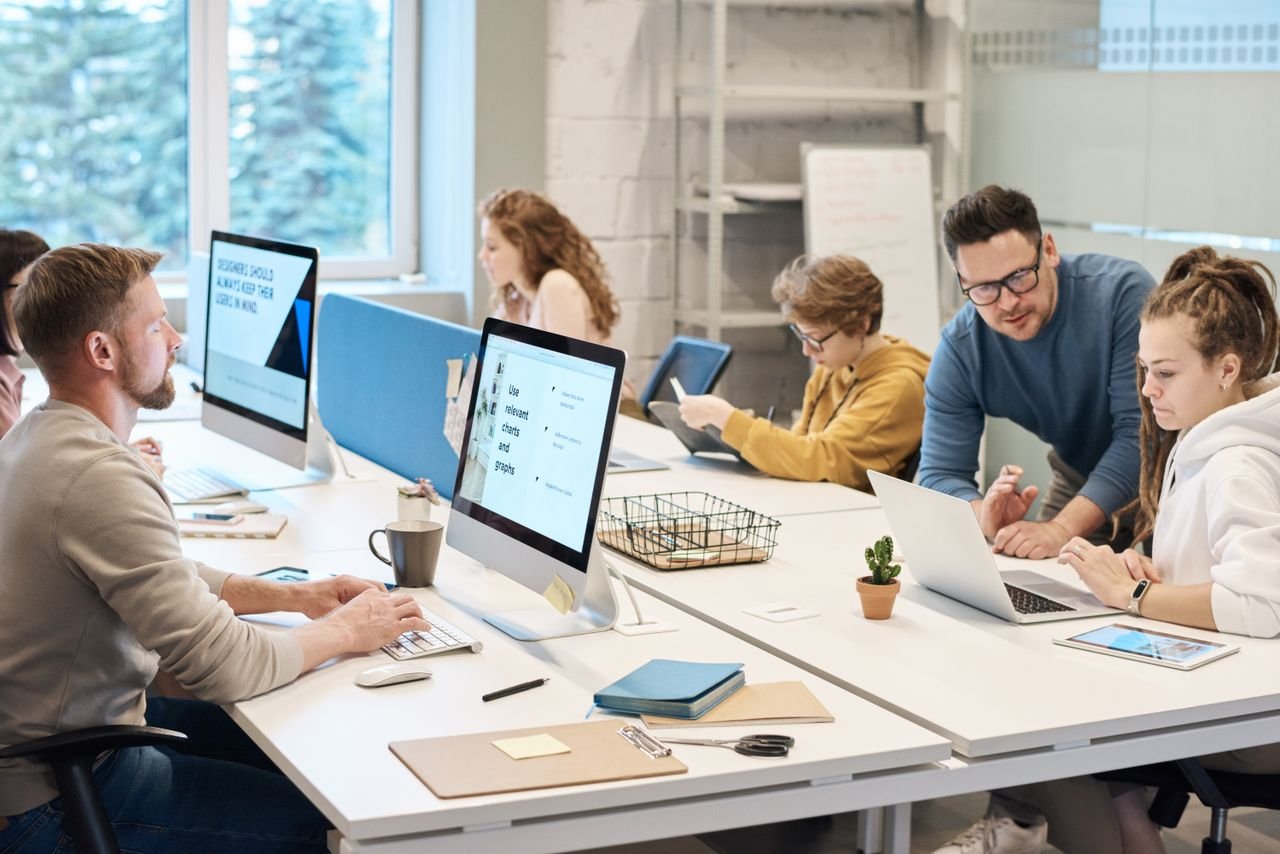 team-01 Team collaboration in a modern office setting with computers and diverse employees working together.